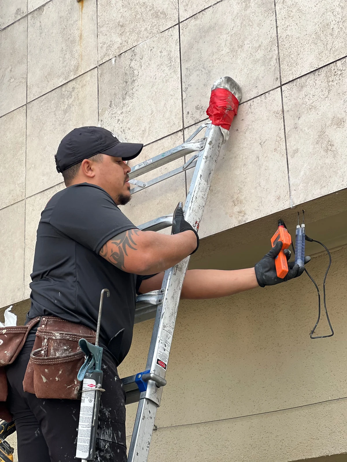 Stucco Check inspector using a probe and moisture meter at an exterior wall