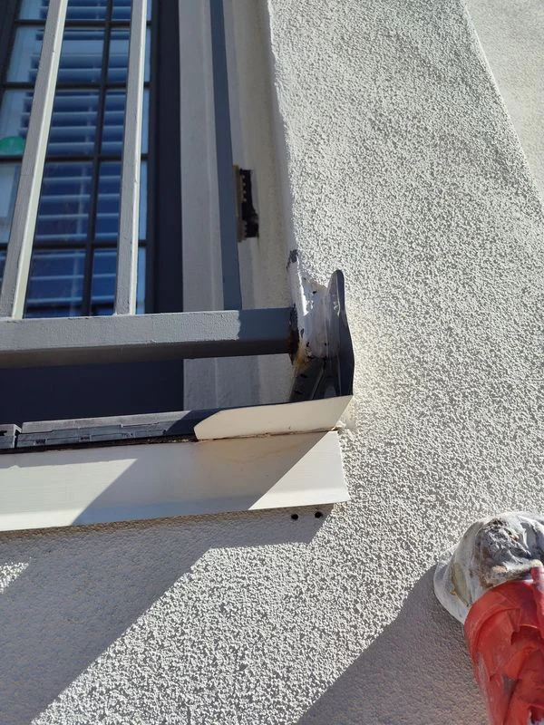Railing attachment and surrounding stucco photographed during an inspection