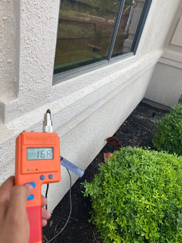Moisture meter used at a stucco window sill